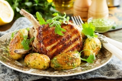 Grilled pork chop on the bone with spicy potatoes. Selective focus.