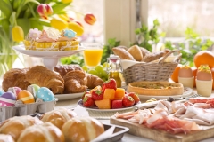 Breakfast or brunch table filled with all sorts of delicious delicatessen ready for an Easter meal.