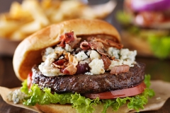 gourmet bacon and bleu cheese burgers with beer in background