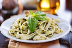 italian fettuccine in basil pesto sauce on table
