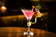 Pink cocktail with cherry and mango in a club.