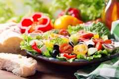 plate of greek salad on wooden table